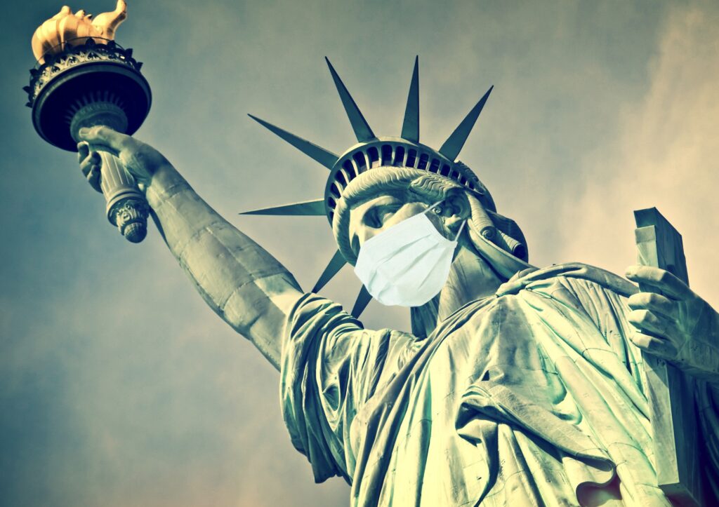 A statue of liberty wearing a surgical mask.