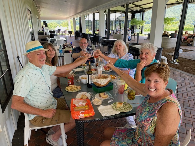 A group of people toasting at an outdoor table.