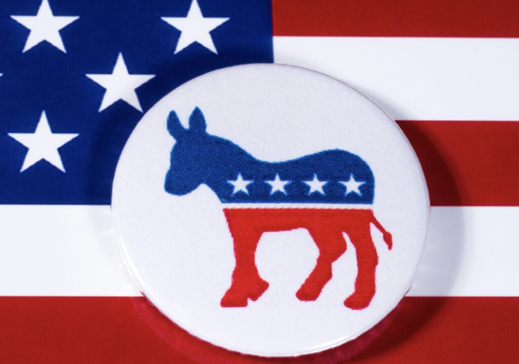 A button with a donkey on it in front of an american flag.