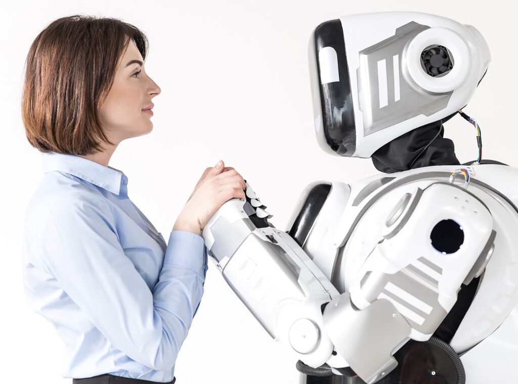 A woman is talking to a robot on a white background.