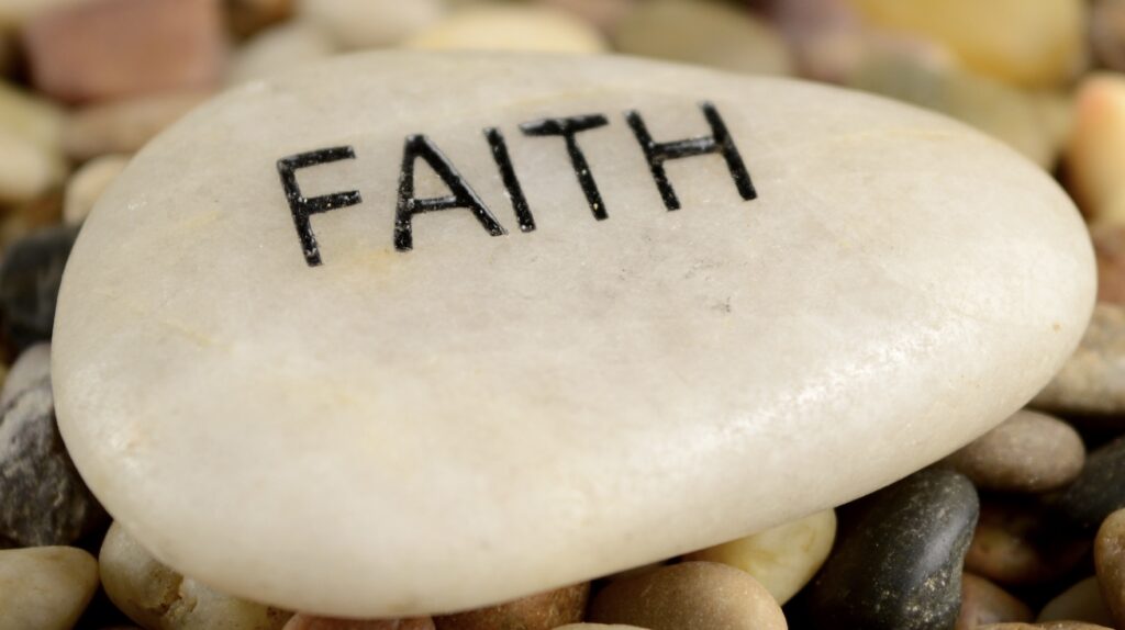 A stone with the word faith written on it.