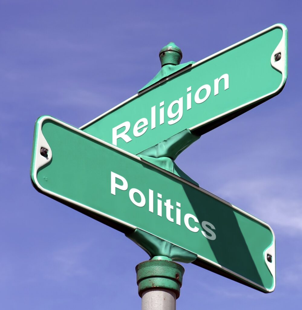 Two street signs with the words religion and politics.