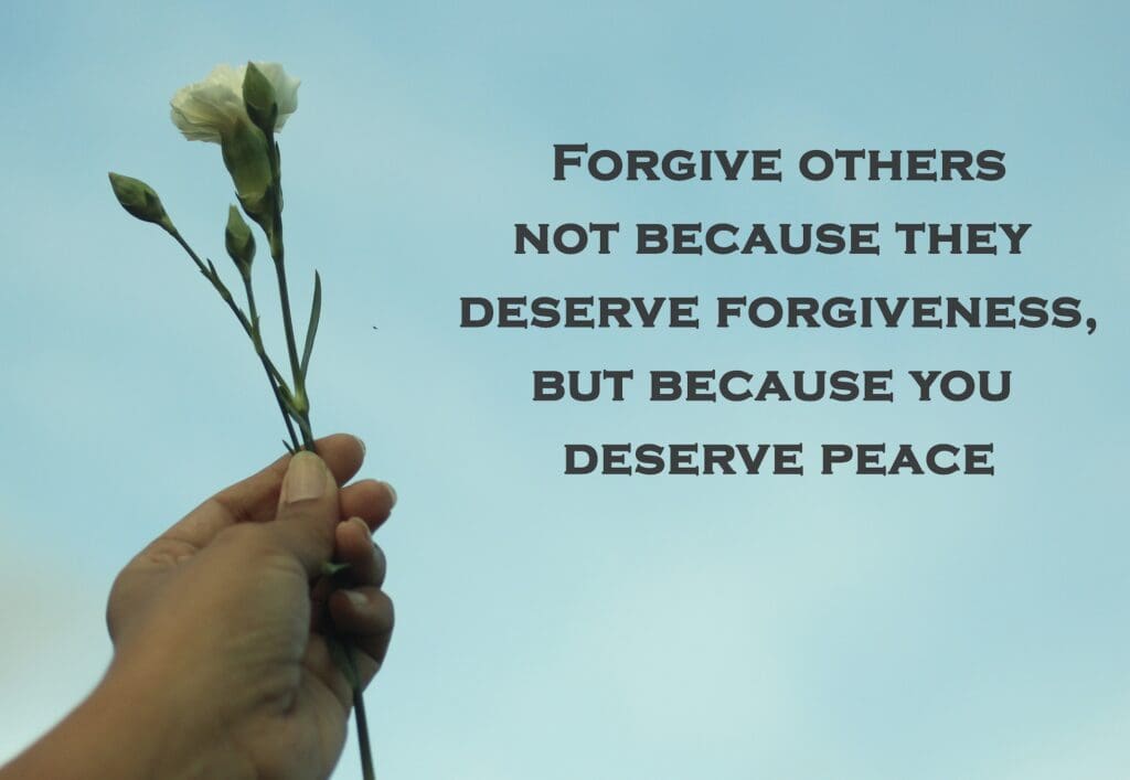 A hand holding a white flower against a blue sky background with the text, "Forgive others not because they deserve forgiveness, but because you deserve peace.