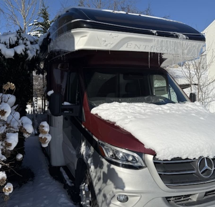 Snow-covered camper van in winter landscape.