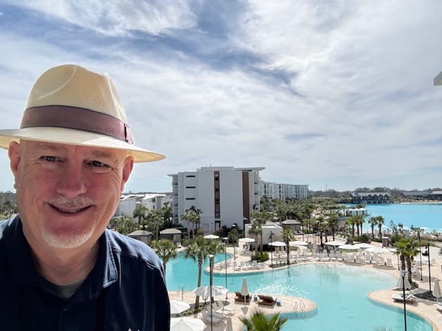 Man smiling in front of a pool.