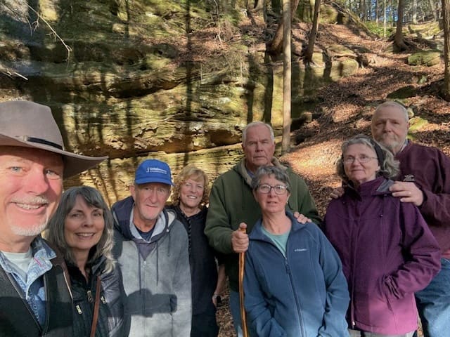 Group of people smiling in a forest.